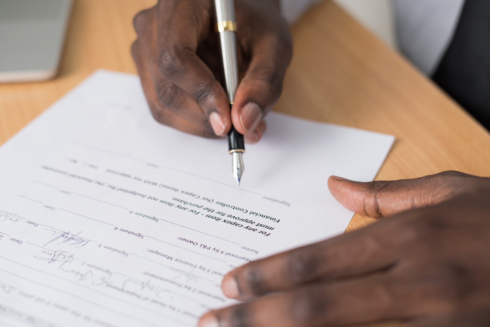 close up photography of person writing on white paper
